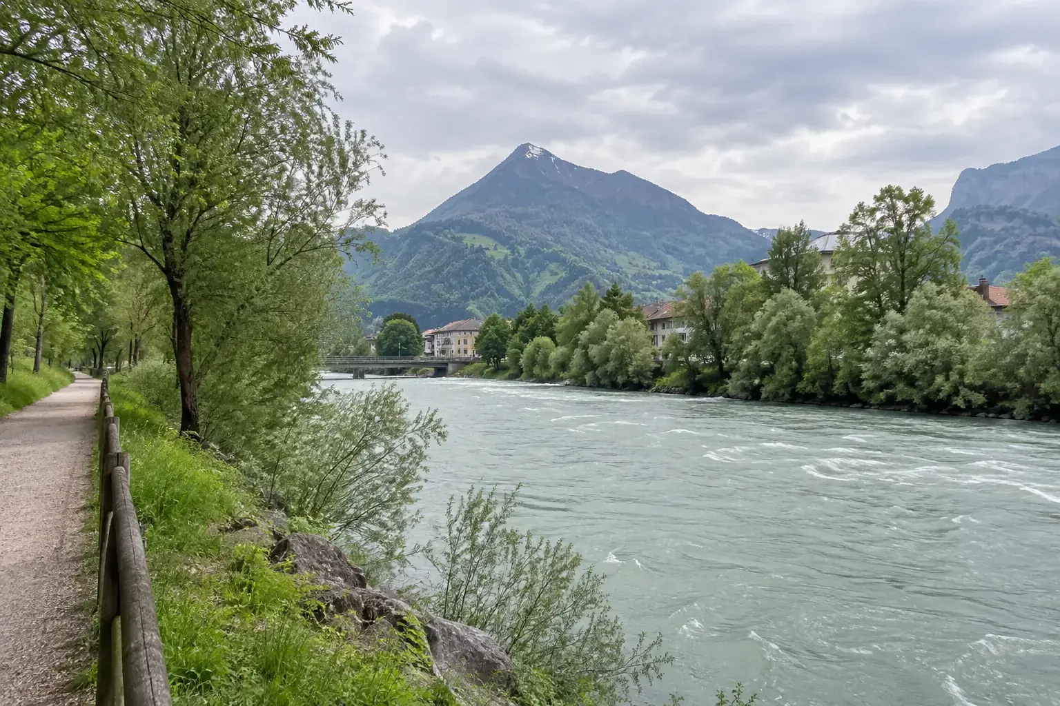 L’Arve à Bonneville : eau vert-gris de montagne, saules et aulnes sur la berge, chemin piéton, silhouette pyramidale du Môle au fond sous un ciel clair de printemps